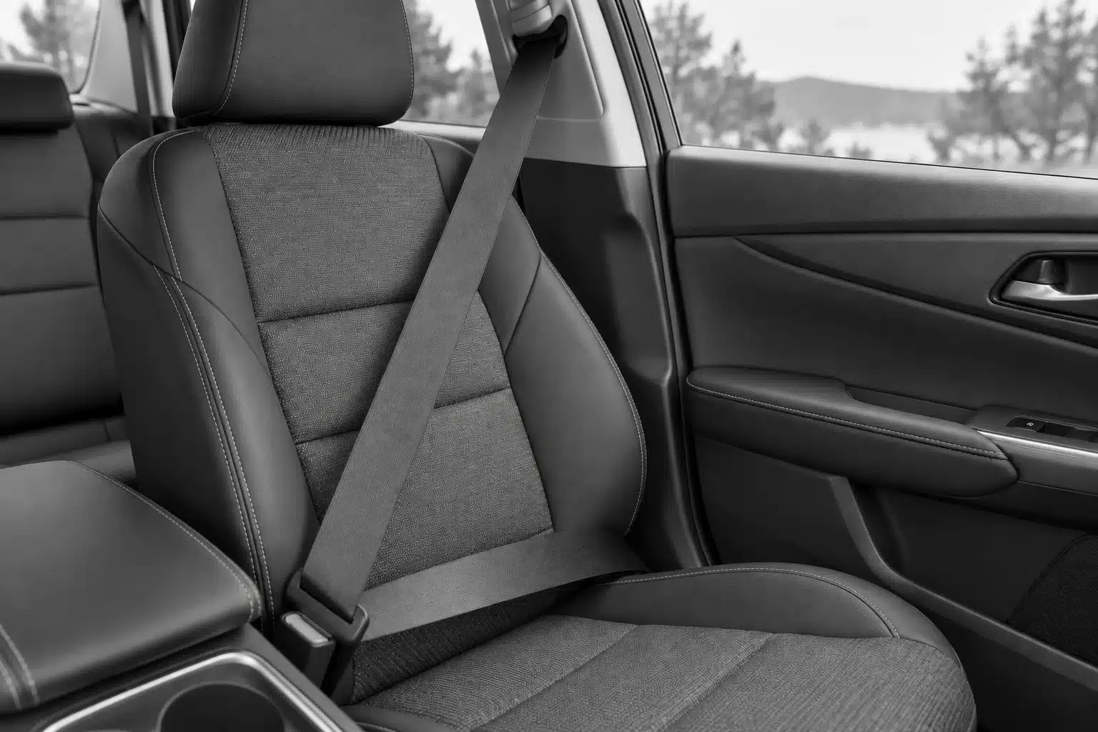 Black-and-white seat belt and buckle on an empty vehicle seat