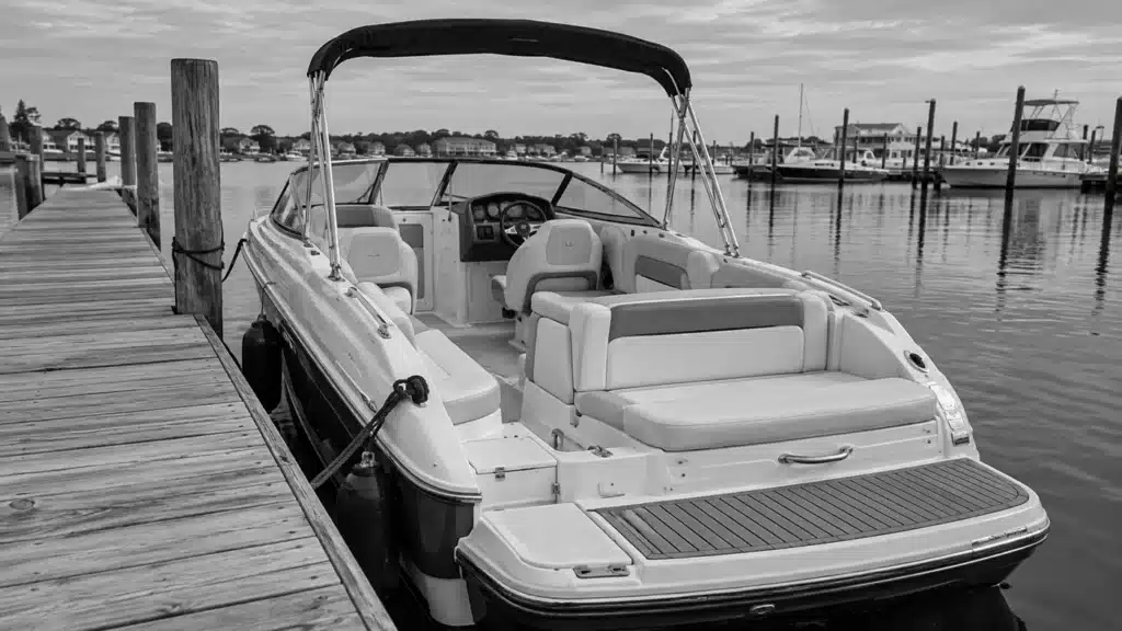 Empty passenger boat with seating and handholds beside a marina dock