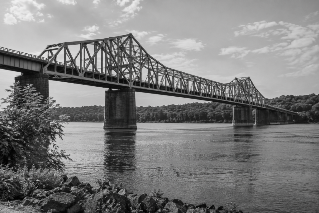Black-and-white steel truss bridge spanning a river