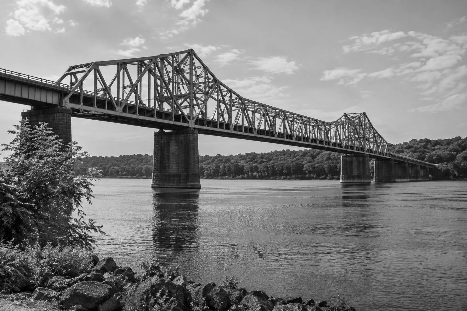 Black-and-white steel truss bridge spanning a river