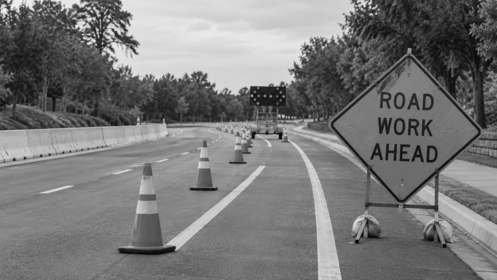 Poorly marked roadwork investigation: temporary cones and a road-work warning sign