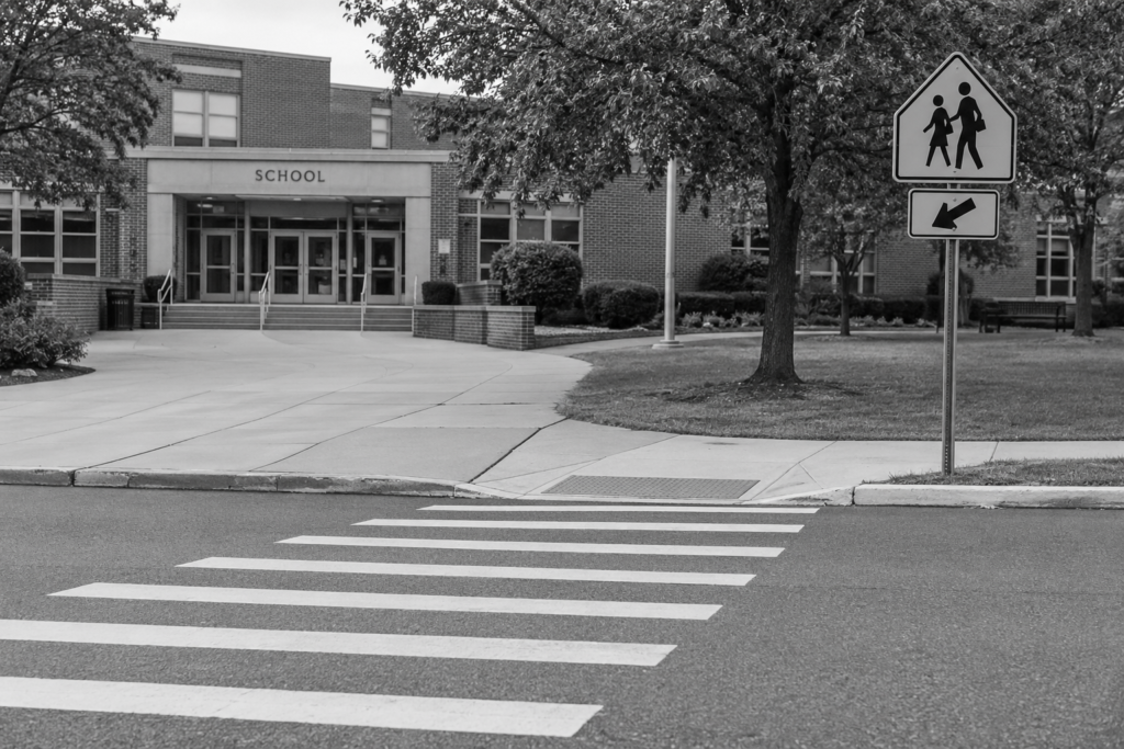 School crossing with marked crosswalk and warning sign