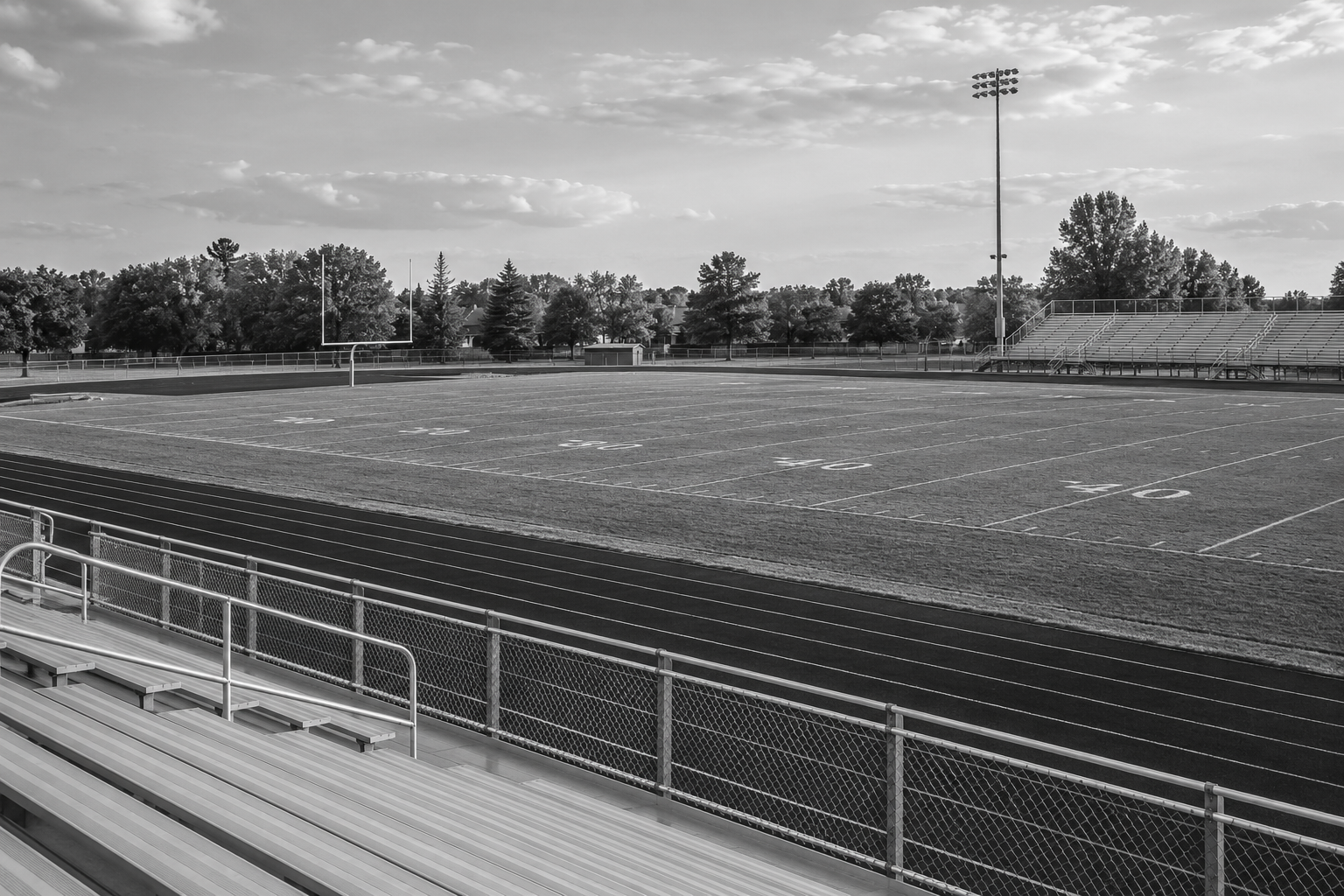 Empty high-school football game field and spectator bleachers