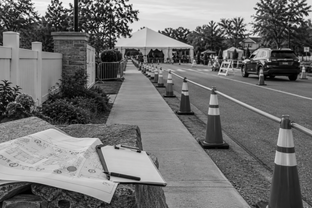 Event traffic plans on a clipboard beside a coned pedestrian route